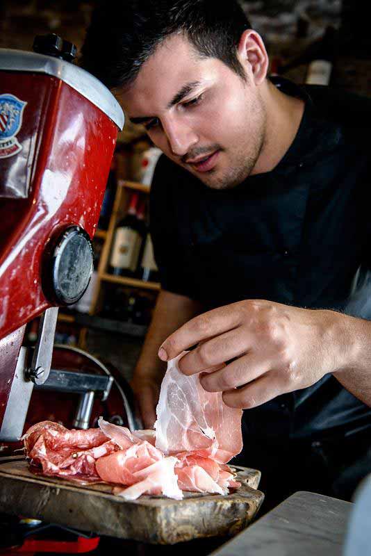 Preparazione del Tagliere del Boccanegra con affettati, carciofi, olive nere, pecorino  e altre specialità toscane.
